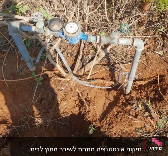 צנרת מים עם מד מים וברזים בשטח פתוח